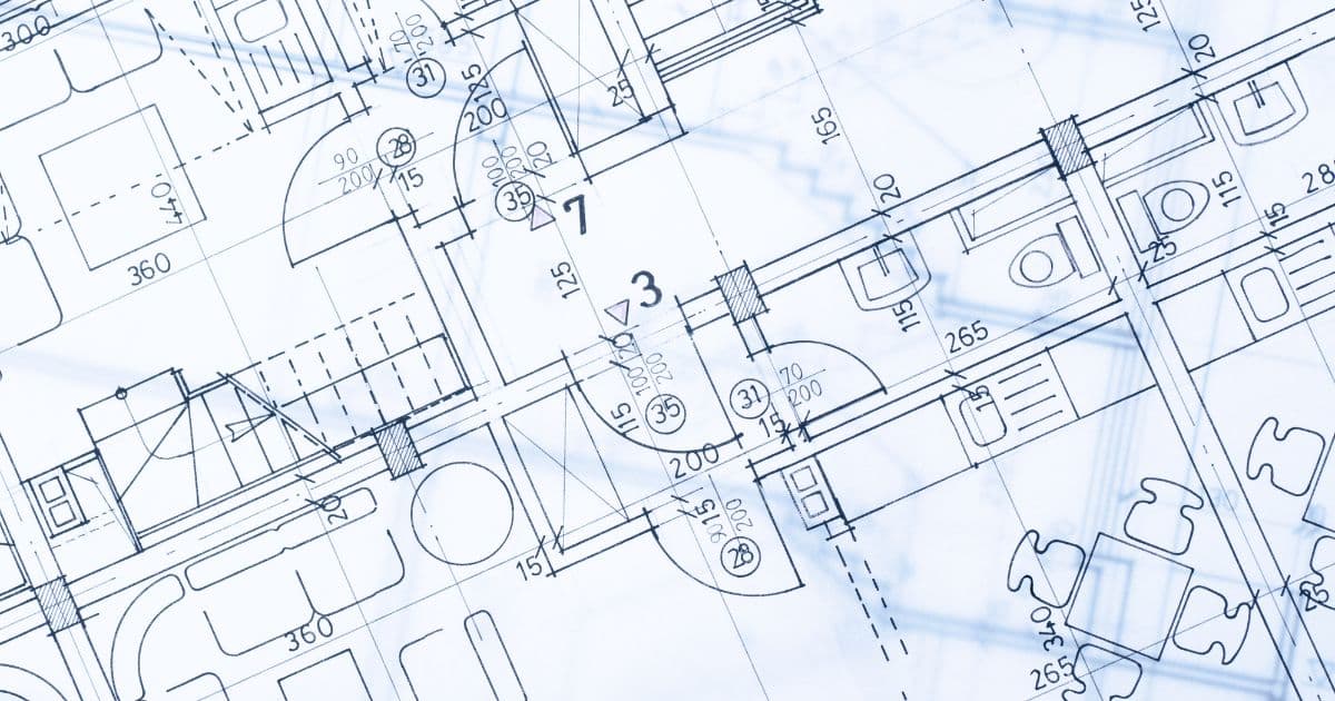 Close-up view of architectural blueprints showcasing detailed floor plans with measurements and annotations.