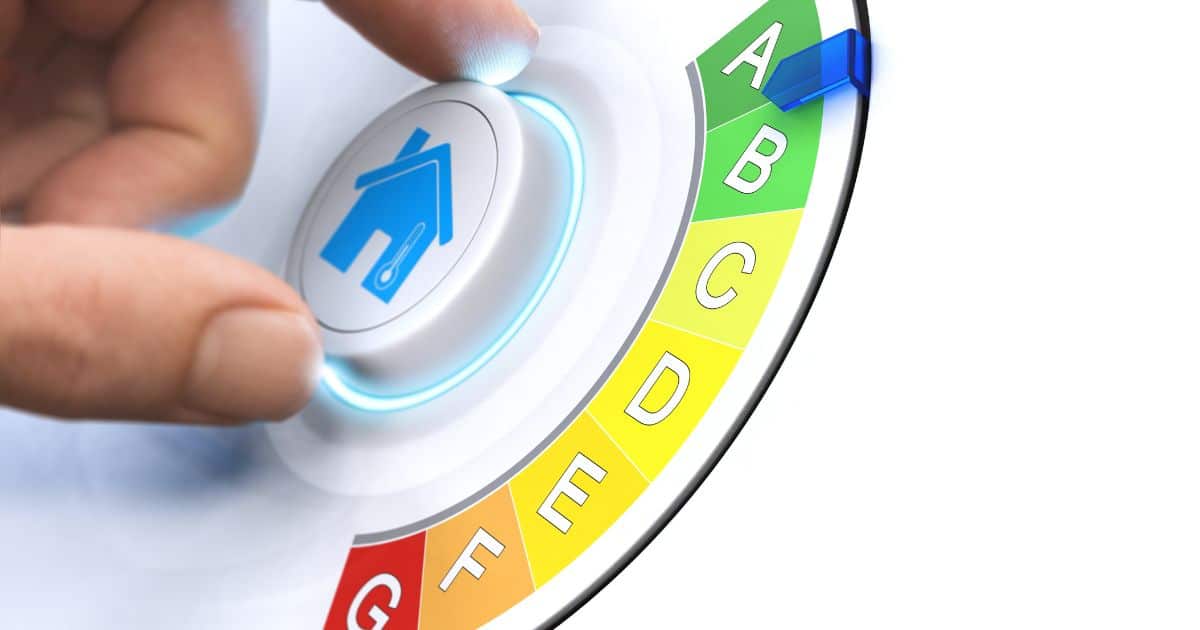 A hand adjusting a circular mechanical engineering control with a colorful dial labeled a to g and a highlighted energy efficiency symbol.