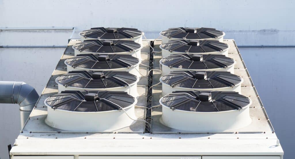 A group of air conditioners on top of a building.