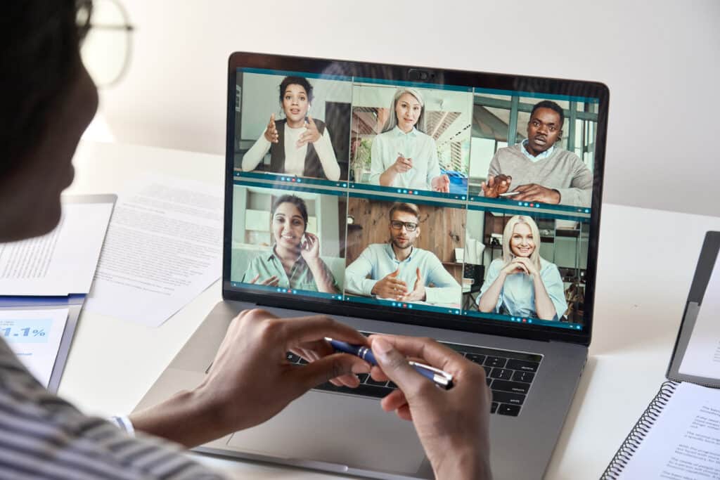 A group of people on a laptop using a video conference.