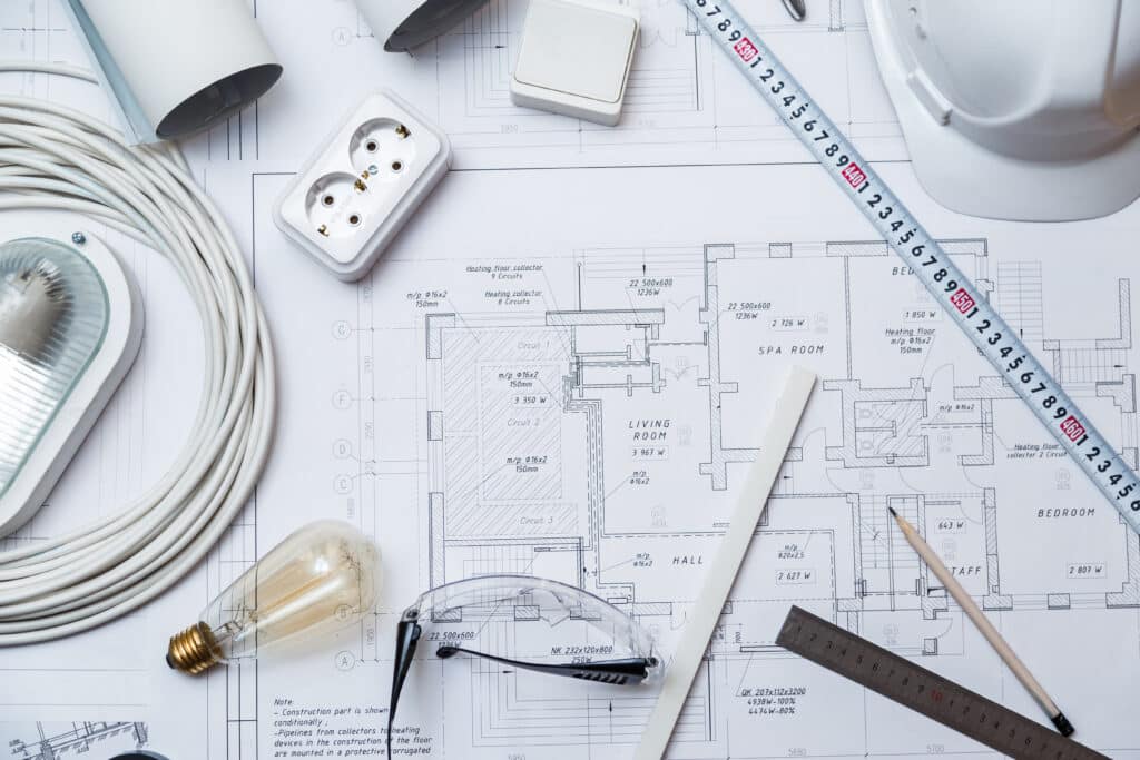 A collection of electrical equipment and tools on top of a blueprint.