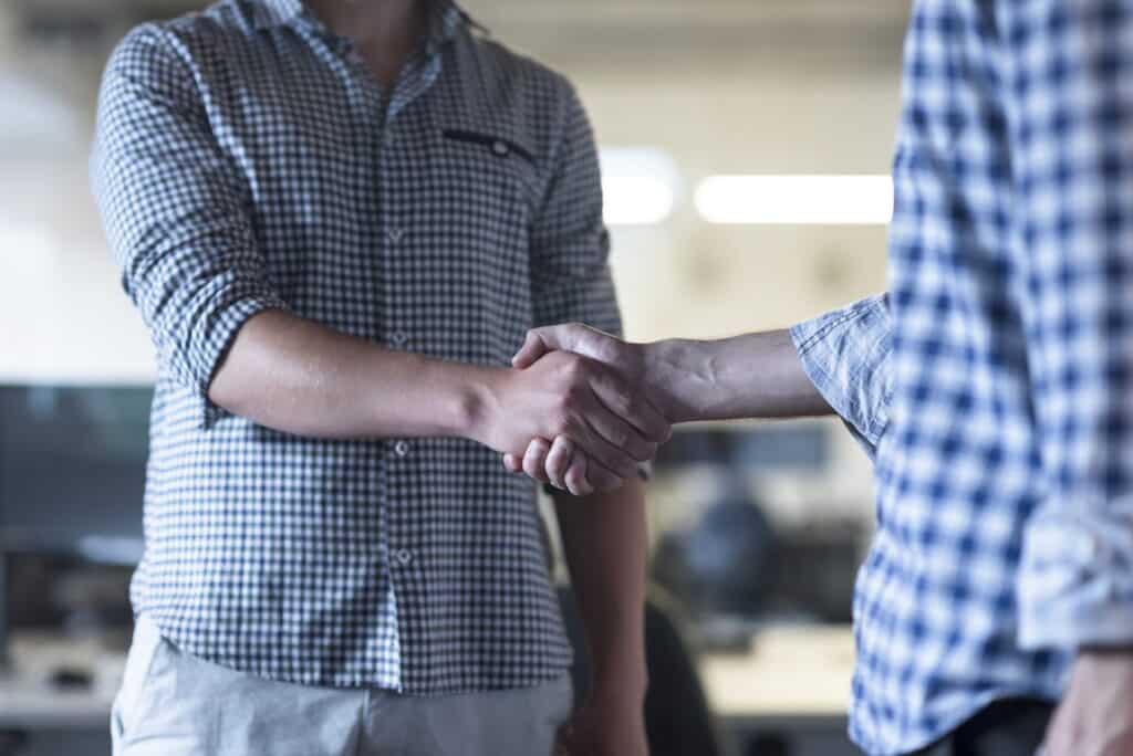 Two men shaking hands in an office.