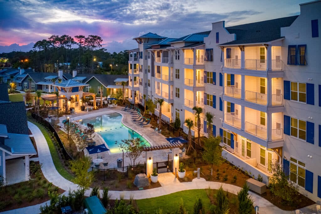 An apartment complex with a swimming pool at dusk.