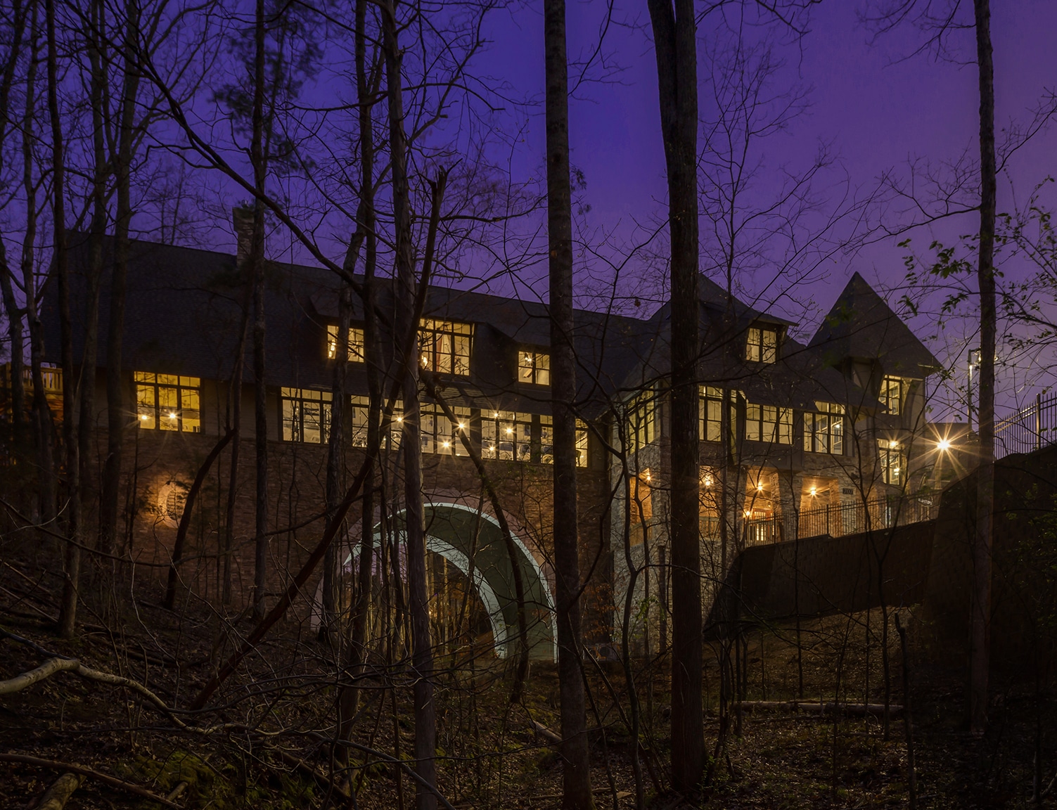 A large mansion in the woods at night.