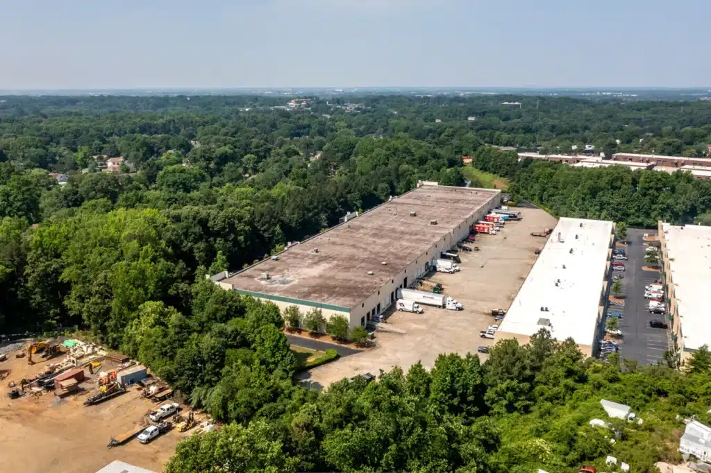 An aerial view of a warehouse in a wooded area.