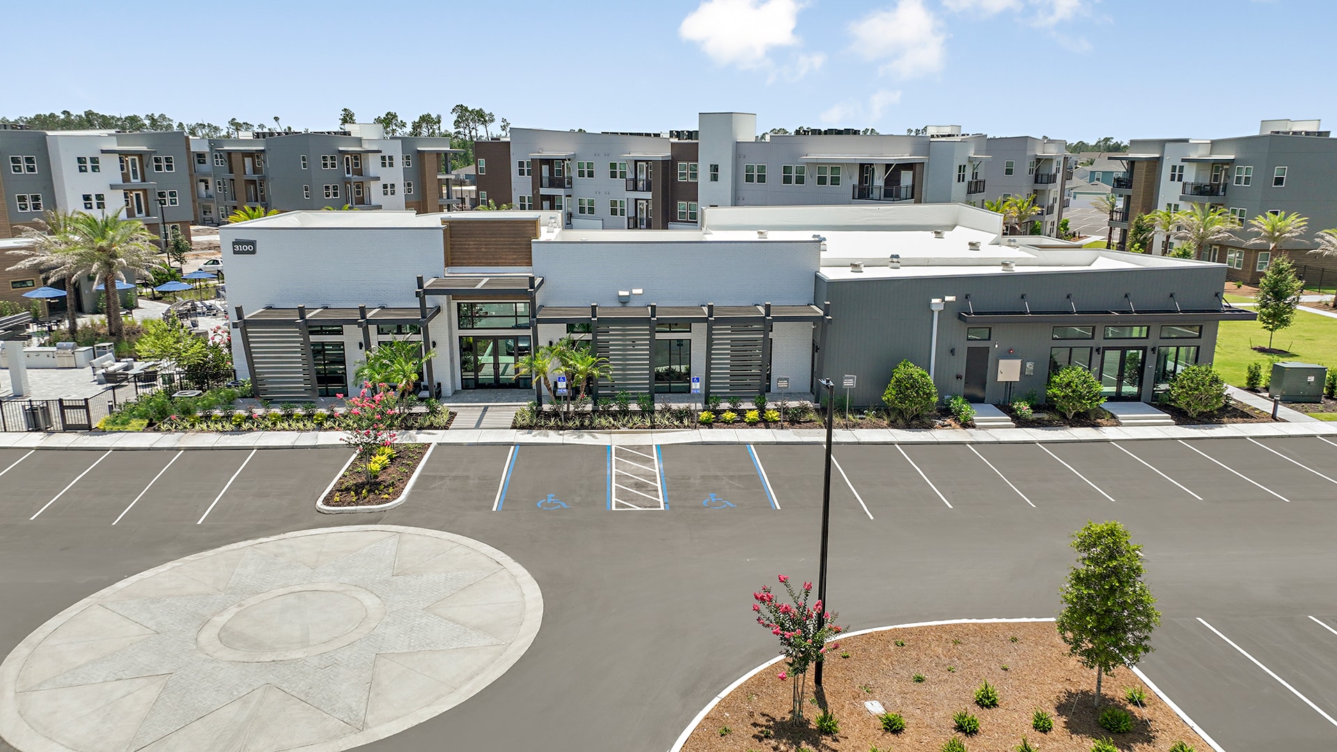 An aerial view of an apartment complex with a parking lot.