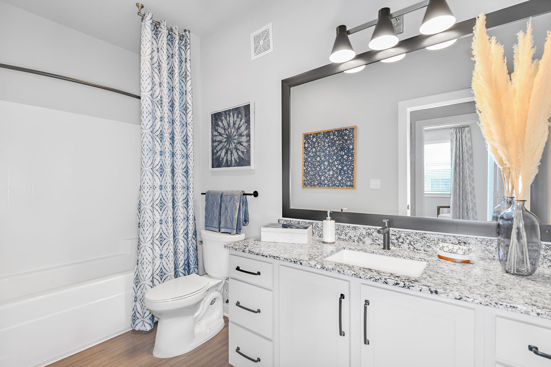 A bathroom with white cabinets and blue accents.