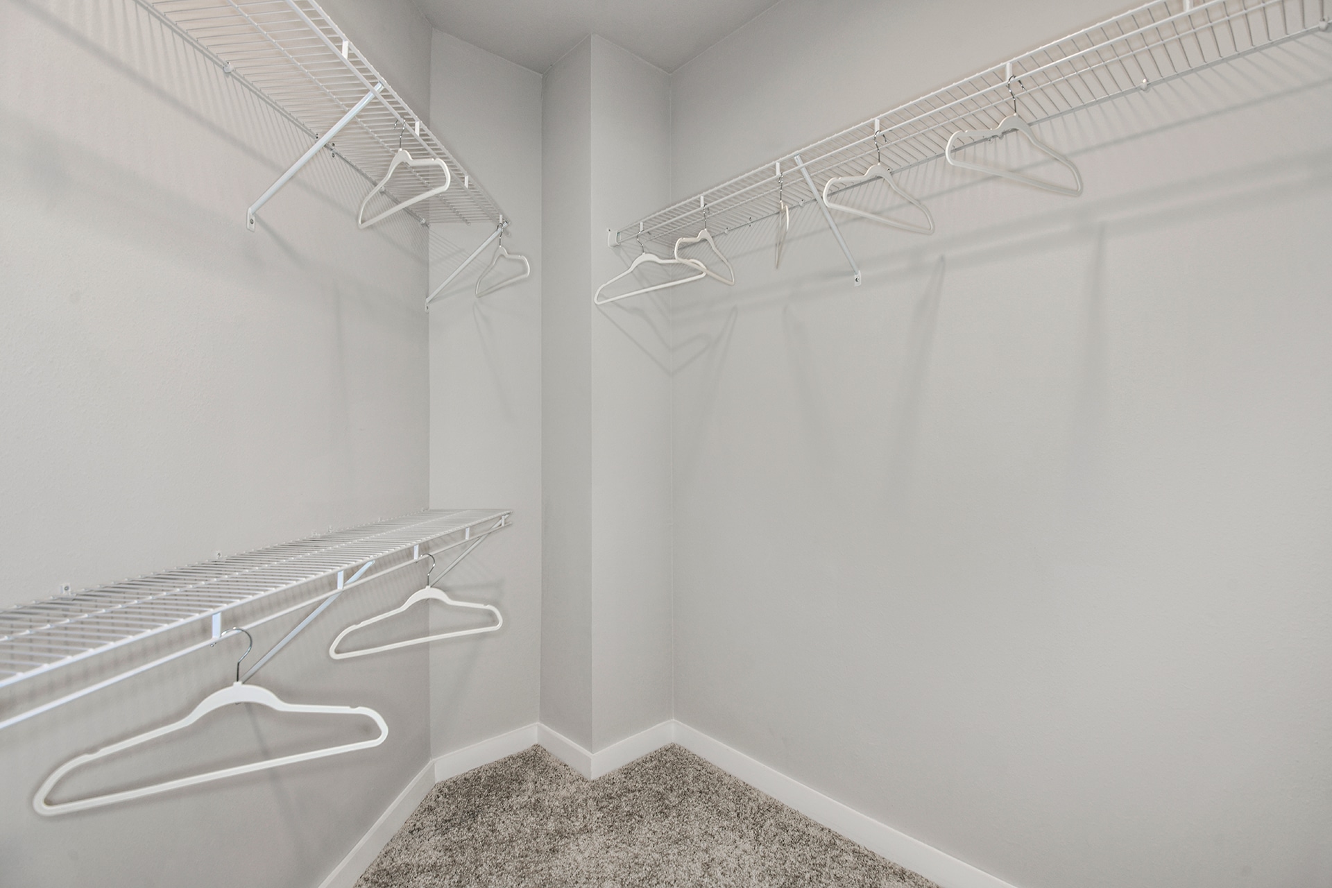 A walk in closet with clothes hanging on the racks.