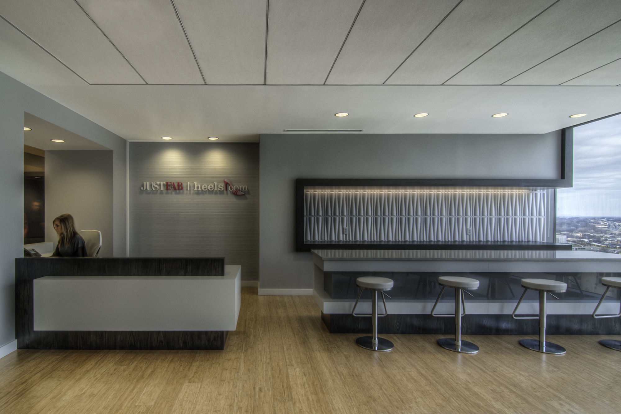A modern office with a reception area and bar stools.