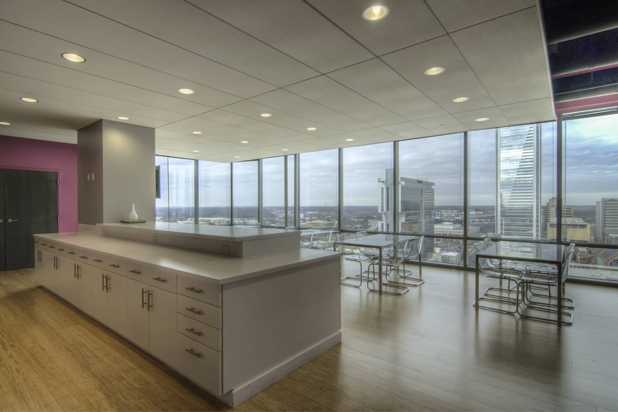 An office with large windows overlooking a city.