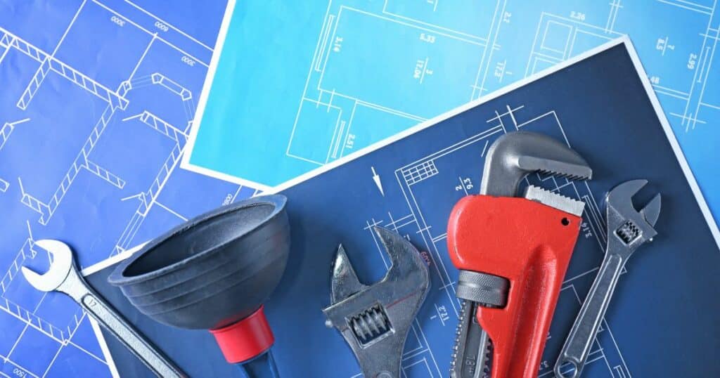 A group of tools and blueprints on a blue background.
