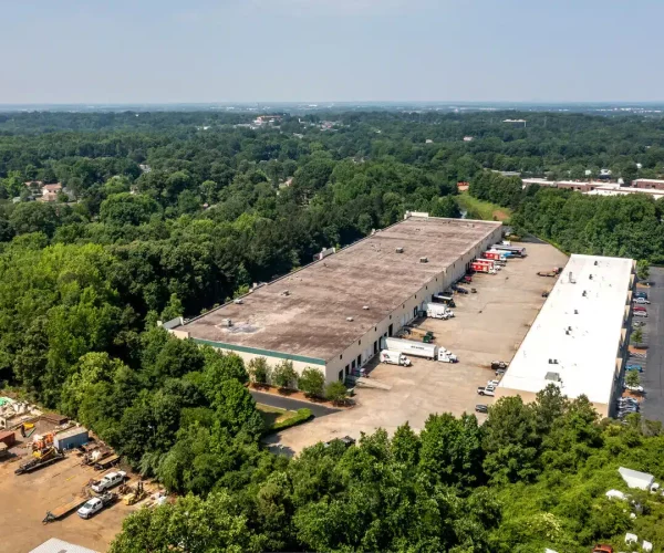 An aerial view of a warehouse in a wooded area.
